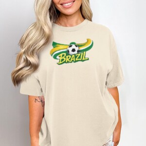 Cream t-shirt with "BRAZIL" text and a soccer ball graphic.