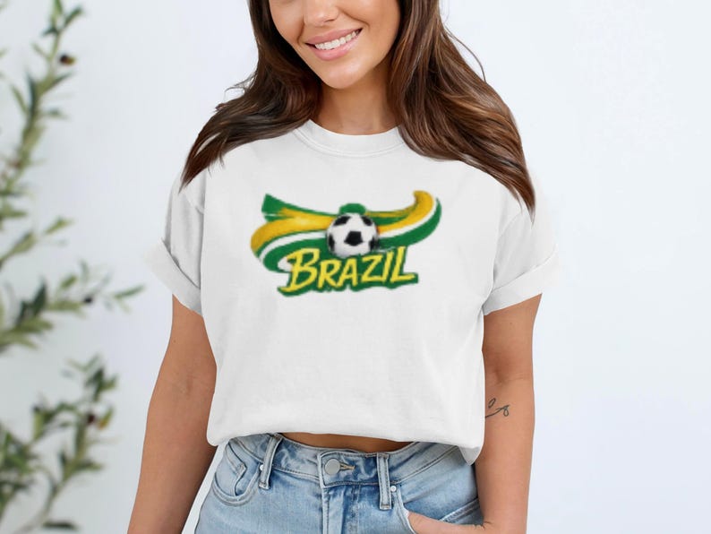 White t-shirt with Brazil soccer logo featuring a soccer ball and wavy flag colors.
