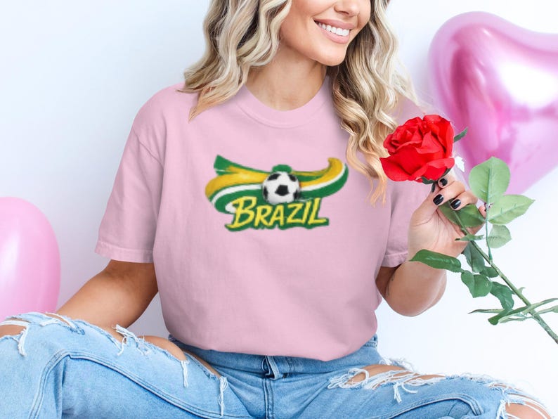 Woman in pink shirt with Brazil soccer logo holding a red rose.