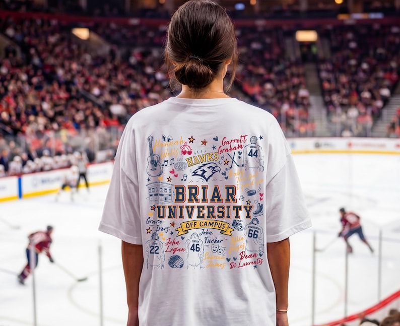 May include: A white t-shirt featuring a colorful graphic on the back with the text Briar University Off Campus, surrounded by illustrations of hockey jerseys, a guitar, a building, and various names written in cursive script and block lettering.