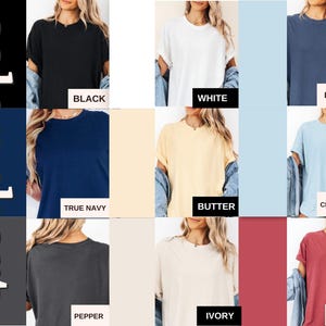 May include: A color chart displaying nine short-sleeve t-shirts in various solid colors labeled as black, white, denim, true navy, butter, chamberay, pepper, ivory, and crimson. Each shirt features a crew neckline and rolled sleeve cuffs.