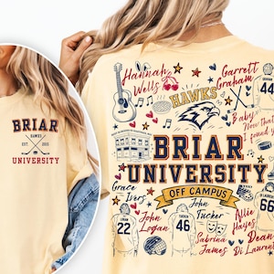 May include: A pale yellow t-shirt featuring a small Briar University logo on the front left chest and a large, detailed graphic on the back. The back design includes the text Briar University, hockey jerseys, a guitar, and various names.