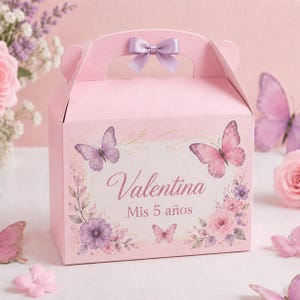 May include: A light pink cardboard gift box with a handle, featuring a lavender ribbon bow. The front displays the name Valentina, the text Mis 5 años, and illustrations of pink and purple butterflies, roses, and floral sprigs in a soft design.