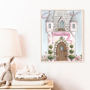 May include: A watercolor painting of a pink castle with a banner that reads "Princess Olivia". The castle has a brown door and is surrounded by green bushes and flowers.