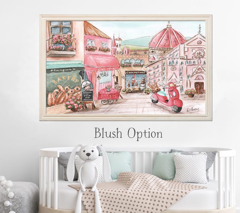 K&ouml;nnte beinhalten: Ein gerahmter Druck im Aquarellstil mit einer europ&auml;ischen Stra&szlig;enszene in Rosa- und Cremet&ouml;nen. Die Illustration zeigt eine B&auml;ckerei, ein Caf&eacute;, ein gro&szlig;es Kuppelgeb&auml;ude und einen roten Roller auf einem Kopfsteinpflasterweg. Der Text Blush Option steht darunter.