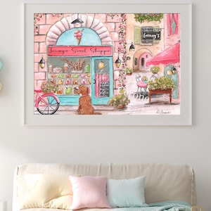 K&ouml;nnte beinhalten: Eine gerahmte Aquarellillustration eines Ladengesch&auml;fts namens Lainey's Sweet Shoppe mit t&uuml;rkisfarbenem Rahmen, rosafarbenen Ziegelw&auml;nden und einem Eist&uuml;ten-Schild. Ein brauner Hund sitzt drau&szlig;en bei einem rosa Fahrrad, mit Markise und Blumen.