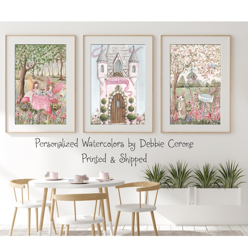 K&ouml;nnte beinhalten: Drei gerahmte Aquarelldrucke. Der linke Druck zeigt Feen bei einer Teeparty. Der mittlere Druck zeigt ein rosa Schloss mit dem Namen "Princess Olivia". Der rechte Druck zeigt ein Kaninchen in einem Garten. Der Text "Personalized Watercolors by Debbie Cerone" steht darunter.