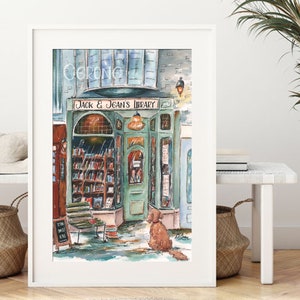 May include: A watercolor painting of a bookstore with the name "Jack & Jean's Library" above the door. The storefront is painted in shades of green and brown, with a dog sitting in front of the entrance. The painting has a whimsical and charming style.