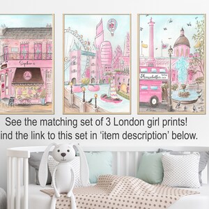 May include: A set of three watercolor prints featuring pink and blue illustrations of London landmarks. The prints include a pink double-decker bus, a pink building with a fountain, and a pink building with a bakery.