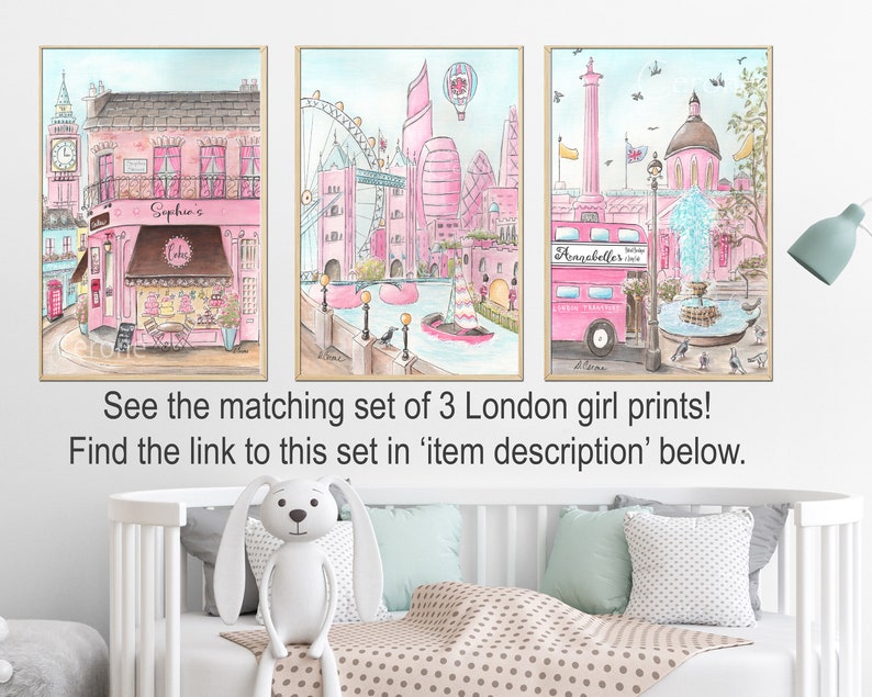 May include: A set of three watercolor prints featuring pink and blue illustrations of London landmarks. The prints include a pink double-decker bus, a pink building with a fountain, and a pink building with a bakery.