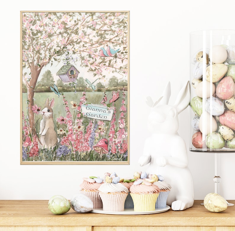 Puede incluir: Una pintura de acuarela de una escena de jard&iacute;n caprichosa con un conejito, flores, una casita de p&aacute;jaros y un letrero que dice "El jard&iacute;n de Gianna".
