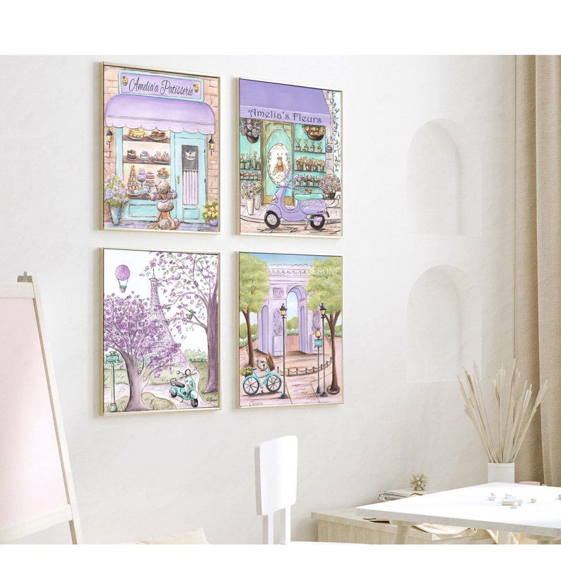 May include: Four framed illustrations of Parisian scenes. The top left image shows a pastel pink and blue storefront with the text "Amelie's Patisserie". The top right image shows a pastel pink and blue storefront with the text "Amelie's Fleurs". The bottom left image shows a purple Eiffel Tower with a hot air balloon in the sky. The bottom right image shows a purple archway with a bicycle in front of it.
