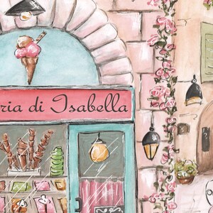K&ouml;nnte beinhalten: Eine Aquarellillustration eines Ladenlokals mit der Aufschrift Gelateria di Isabella auf einem rosa Schild, einem Schaufenster mit Eist&uuml;ten und Beh&auml;ltern sowie einem Nachbargeb&auml;ude mit einem Schild namens Bella's, verziert mit rosa Rosen.