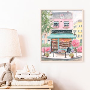 May include: A watercolor painting of a pink building with a green awning that says "Olivia's Bookshop". The building is on a street corner with trees and flowers. The text "Cerone" is written in the top left corner of the painting.