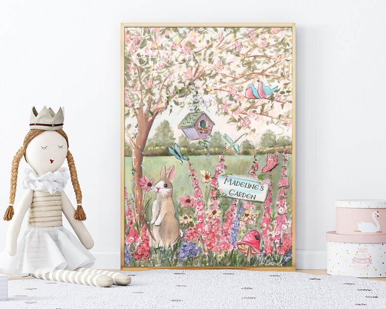 Puede incluir: Una ilustraci&oacute;n caprichosa de un jard&iacute;n con un borde de flores rosa y blancas, una casita para p&aacute;jaros, una mariposa, una lib&eacute;lula y un conejito oliendo una flor. El cartel dice "Jard&iacute;n de Madeline".