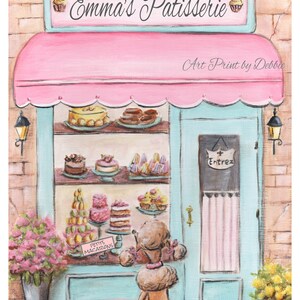 Op de afbeelding: Een kunstafdruk van een roze en blauwe patisserie, "Emma's Patisserie", met een poedel die naar de etalage met taarten en macarons kijkt. De luifel is roze en de deur lichtblauw. Het bord zegt "Entrez".