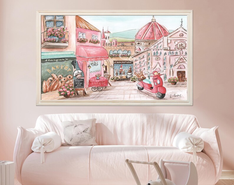 K&ouml;nnte beinhalten: Ein gerahmter Druck im Aquarellstil, der eine europ&auml;ische Stra&szlig;enszene mit einer rosa B&auml;ckerei, einem Caf&eacute; mit Sitzgelegenheiten im Freien, einem roten Roller und einer gro&szlig;en Kathedrale mit Kuppel im Hintergrund zeigt. Das Bild hat sanfte Pastellt&ouml;ne.