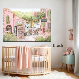 K&ouml;nnte beinhalten: Ein rechteckiger Wandkunstdruck mit einer Aquarellillustration einer rosa K&uuml;stenstadtstra&szlig;e mit einer B&auml;ckerei namens Ellies, einem Fahrrad, einem gelben Segelboot auf dem Wasser, gr&uuml;nen H&uuml;geln und einem rosa Hei&szlig;luftballon am Himmel.