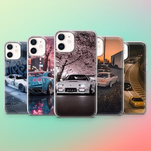Puede incluir: Una colección de cinco fundas para teléfono con diseños de coches. Las fundas muestran varios coches deportivos en diferentes entornos, incluyendo paisajes urbanos y rutas escénicas. Las fundas tienen un acabado transparente y brillante.