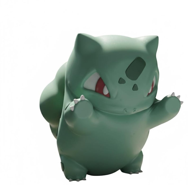Op de afbeelding: Een groene Bulbasaur-figuur met rode ogen en witte klauwen. Het figuur staat in een speelse pose met de armen omhoog. Bulbasaur heeft een grote bol op zijn rug. Populair personage uit de Pok&eacute;mon-franchise.