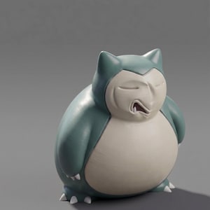 Op de afbeelding: Een beeldje van Snorlax, een groot Pok&eacute;mon, in blauwgroen en cr&egrave;me. De figuur wordt slapend afgebeeld, met gesloten ogen en een licht geopende mond. Het beeldje heeft een gladde, matte afwerking en is een verzamelobject.