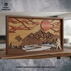 May include: A layered wooden artwork depicting a mountain scene with a deer, Bigfoot, and a river. The piece uses shades of brown, tan, and red, with a sun and clouds. The text "DIGITAL DOWNLOAD" is visible. The artwork is a digital download.