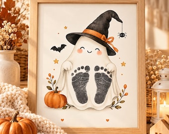 Peut inclure: Une impression encadrée représentant un fantôme blanc portant un chapeau de sorcière noir avec un ruban orange. Le fantôme présente deux empreintes de pieds de bébé noires sur son corps, entouré d'une citrouille orange, d'une chauve-souris, d'une araignée et d'étoiles jaunes.