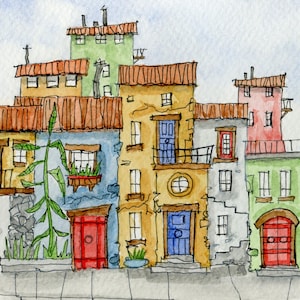 May include: A white ceramic mug with a black handle and the text "But First, Coffee" in a bold, black font. The mug is set against a blurred background, suggesting a cozy setting.