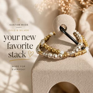 May include: A stack of beaded bracelets featuring alternating gold and silver metallic spheres with small white accent beads. The text on the image reads: CUSTOM MADE, GOLD & SILVER, your new favorite stack, MADE FOR EVERYDAY.