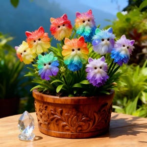 May include: A wooden flower pot filled with green plants and colorful, glittery cat-shaped flower decorations. The cat flowers are in various colors, including red, orange, yellow, green, blue, and purple. A clear crystal prism sits in front of the pot.