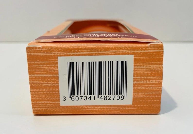 May include: Close-up of an orange rectangular box with a barcode and the number "3 607341 482709". The box has a window at the top, revealing the product inside. The box has a textured surface.