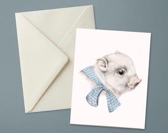 Peut inclure: Une carte de vœux blanche présentant une illustration détaillée d'un porcelet avec un ruban à carreaux bleu clair noué autour du cou, accompagnée d'une enveloppe assortie de couleur crème. Le porcelet est représenté de profil vers la droite.