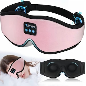 May include: A pink eye mask with a black strap and accents. The mask has the word "Enjoying" and control buttons. The image also shows a person wearing the mask and a black version of the mask.