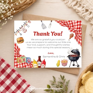 Puede incluir: Una tarjeta de agradecimiento con temática de barbacoa. La tarjeta presenta un patrón de cuadros rojos y blancos, una hamburguesa, una parrilla y las palabras "Thank You!" en rojo. La tarjeta también incluye texto sobre la bienvenida a un nuevo bebé.