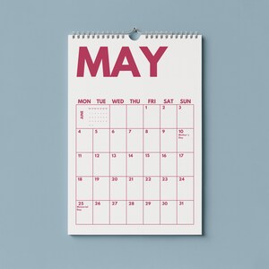 Pu&ograve; includere: Un calendario da parete per il mese di maggio con sfondo bianco e testo rosa scuro. Il calendario presenta una griglia con i giorni della settimana da luned&igrave; a domenica, incluse le date dall'1 al 31, e note per la festa della mamma e Memorial Day.