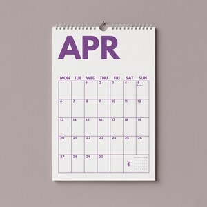 Pu&ograve; includere: Un calendario da parete per il mese di aprile con sfondo bianco e testo e linee della griglia di colore viola. Il calendario mostra i giorni della settimana da luned&igrave; a domenica, con date numerate da 1 a 30 e una piccola anteprima di maggio.