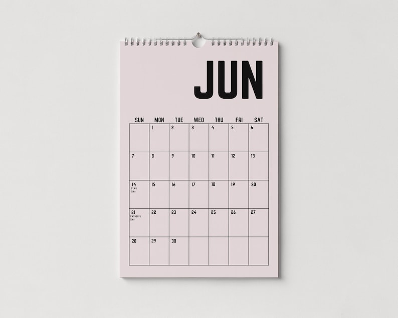 Peut inclure: Un calendrier mural de juin, avec un fond rose clair et du texte noir. Le mot "JUN" est en haut, avec les jours de la semaine en haut. La grille du calendrier est soulign&eacute;e en noir, avec les dates et les jours sp&eacute;ciaux not&eacute;s.