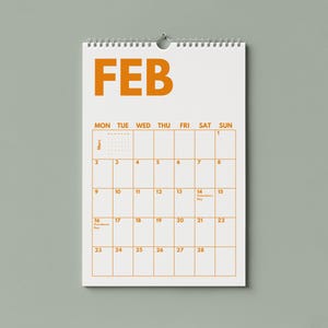 Pu&ograve; includere: Un calendario da parete per il mese di febbraio con sfondo bianco e testo arancione. Il calendario presenta una griglia con i giorni della settimana da luned&igrave; a domenica, date numerate da 1 a 28 e una rilegatura a spirale metallica in alto.
