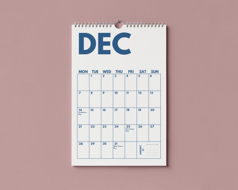 Pu&ograve; includere: Un calendario da parete bianco per il mese di dicembre con testo e linee della griglia in blu scuro. Il calendario presenta una rilegatura a spirale nella parte superiore, i giorni della settimana da luned&igrave; a domenica e date da 1 a 31 in blu.