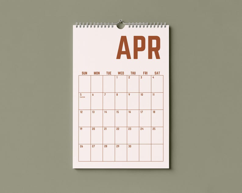May include: A wall calendar for April, featuring a spiral binding and a simple design. The word "APR" is printed in a bold, brown font at the top. The calendar grid is outlined in brown, with dates and days of the week clearly marked.