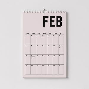 Peut inclure: Un calendrier mural rose pour f&eacute;vrier, avec du texte et des lignes de grille noirs. Le mot "FEB" est en haut, avec les jours de la semaine list&eacute;s en dessous. Le calendrier comprend les dates et les notes de la Saint-Valentin et du jour des Pr&eacute;sidents.