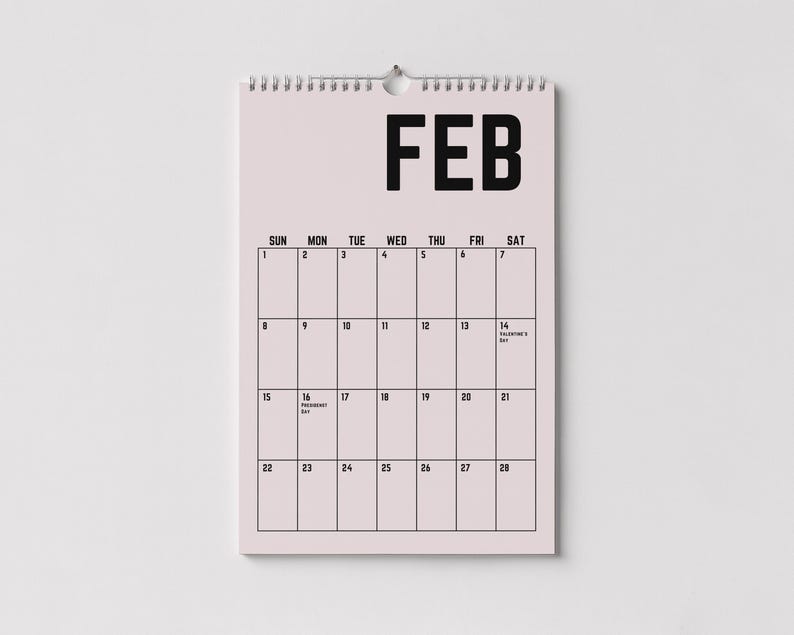 Peut inclure: Un calendrier mural rose pour f&eacute;vrier, avec du texte et des lignes de grille noirs. Le mot "FEB" est en haut, avec les jours de la semaine list&eacute;s en dessous. Le calendrier comprend les dates et les notes de la Saint-Valentin et du jour des Pr&eacute;sidents.