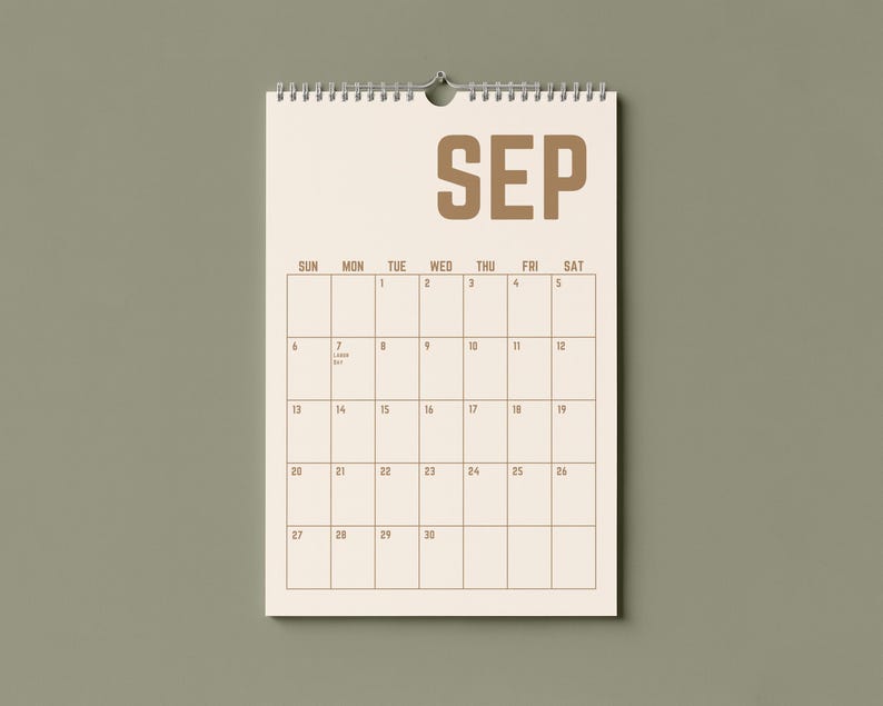 May include: A beige wall calendar for September, hanging against a muted green background. The word "SEP" is printed in a bold, brown font at the top. The calendar grid is visible, with dates and days of the week.