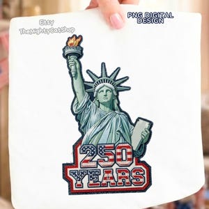 Könnte beinhalten: Ein weißes Stoffstück mit einer detaillierten Illustration der Freiheitsstatue, die eine Fackel und eine Tafel hält. Das Design enthält den Text "250 YEARS" in Rot, Weiß und Blau, mit einer dunkelblauen Umrandung. Der Artikel ist mit "PNG DIGITAL DESIGN" beschriftet.