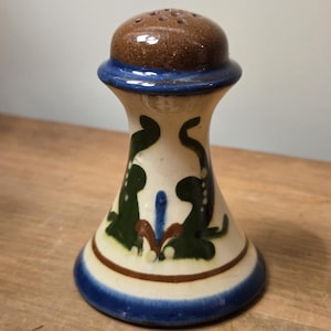 Può includere: Una tazza di ceramica bianca con manico nero e la scritta "But First, Coffee" in stile scritto a mano. La tazza è su una superficie bianca. La tazza è alta 10 cm.