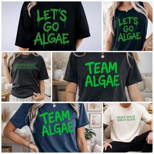 May include: A collection of short-sleeved t-shirts and a tank top in black, dark gray, and cream colors. The garments feature green text prints that read LET'S GO ALGAE, TEAM ALGAE, or MAKE ALGAE GREAT AGAIN in various fonts and styles.