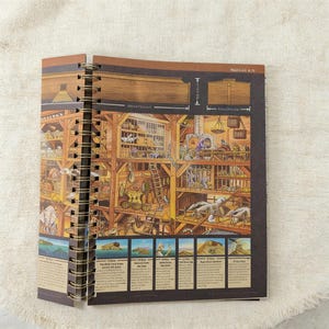 May include: A spiral-bound book with a detailed illustration of Noah's Ark. The artwork depicts the ark's interior with animals and various compartments. The book is open, revealing the colorful illustration and text.