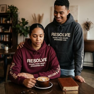 May include: A maroon hoodie and a charcoal gray hoodie, both featuring the text RESOLVE GUARD YOUR HEART (PROVERBS 4:23) on the chest. The maroon hoodie has Peace over Petty on the sleeve, while both hoodies display FAITH IN MOTION on the sleeve.