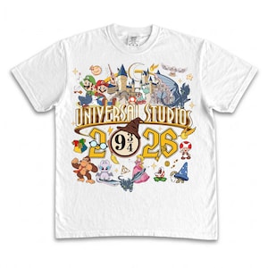 May include: White t-shirt featuring a colorful graphic design with characters from Super Mario, Harry Potter, and other Universal Studios attractions. The design includes the text "Universal Studios" and the numbers "2026".