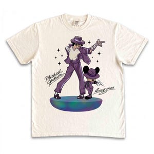 May include: Off-white t-shirt featuring a cartoon illustration of Michael Jackson and Mickey Mouse in matching purple outfits. The text "Michael Jackson" and "Mickey Mouse" are written in cursive. The design is on a round, multi-colored platform.